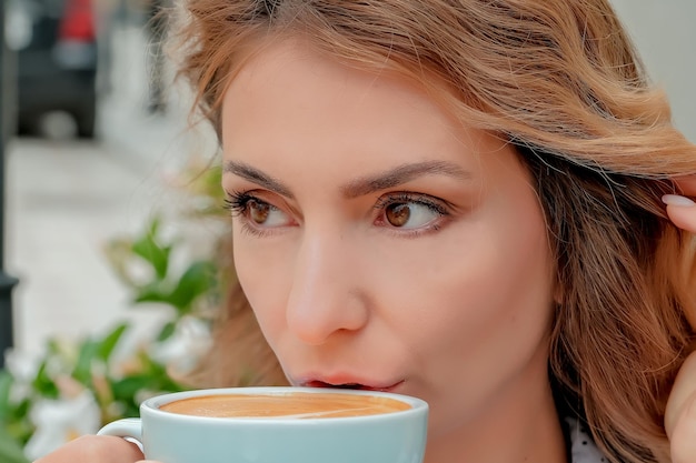 Girl drinking coffee on the street a cup of coffee a cup of coffee and a girl's face closeup