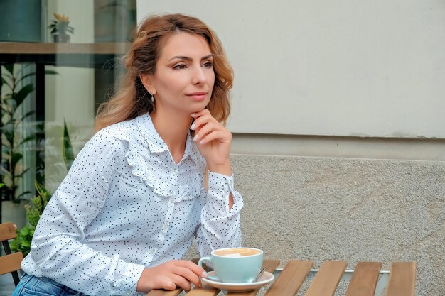 Girl drinking coffee on the street Street Cafe beautiful girl and coffee