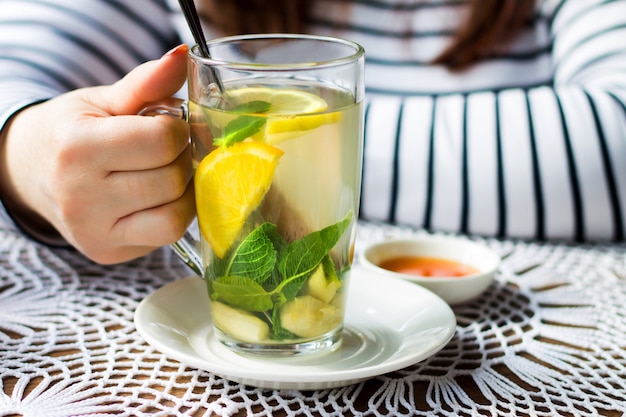 Girl drinking fruit orange tea with mint, ginger and cinnamon. 