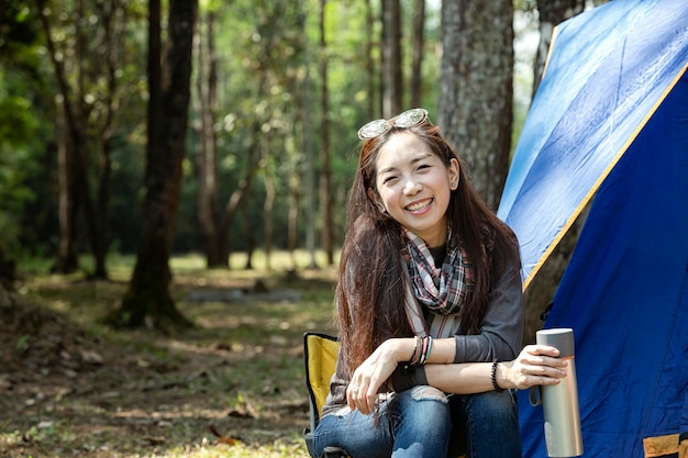 Photo girl drinking hot water in camping beautiful young woman with a tent of outdoor