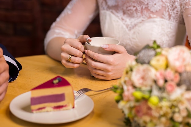 Girl drinks coffee with fruit cakes at a cafe