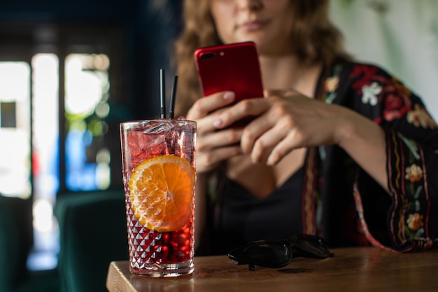 the girl drinks a delicious sweet cocktail and looks into the phone amazing relaxing day