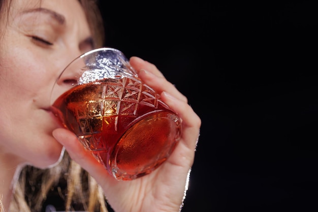 A girl drinks a negroni cocktail on the terrace of a modern restaurant