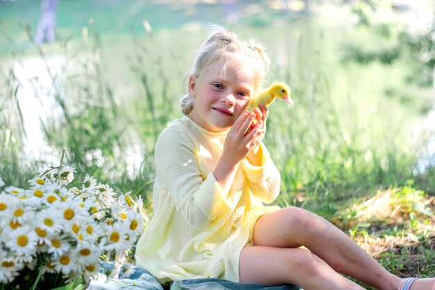 A girl and a duckling in the summer outdoors Gute babies Happiness