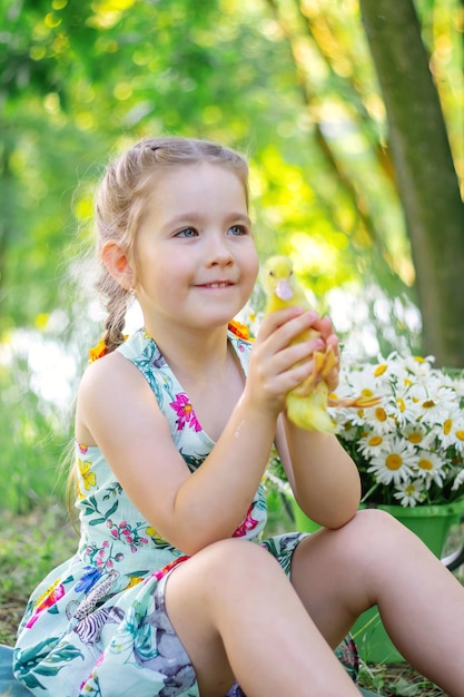 A girl and a duckling in the summer outdoors Gute babies Happiness