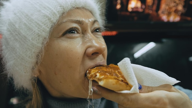 Girl eat pizza cheese four Close up of young woman mouth greedily eating pizza and chewing in outdoor restaurant Human hands taking pieces slices of hot tasty italian pizza from open box Junk food