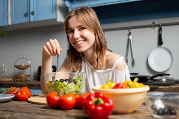 girl eating vegetarian salad in the kitchen