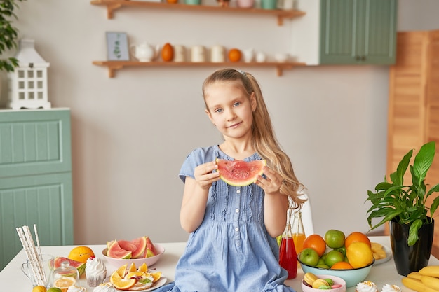 Girl eats fruit at the kitchen