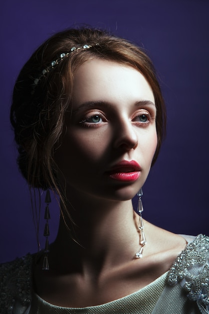 Girl in an elegant dress posing in a studio