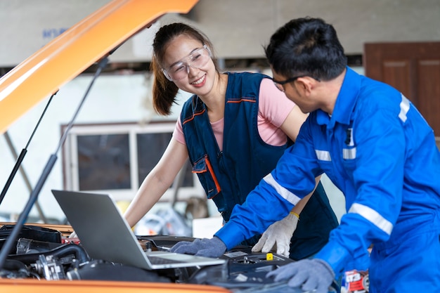 Girl engineer mechanics working on a vehicle in a garage or service wo