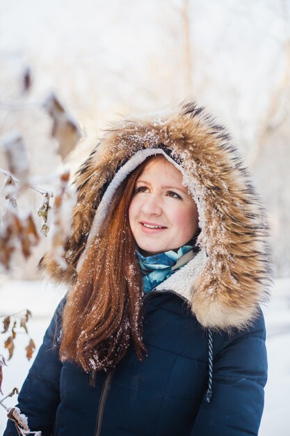 Girl of European appearance on a walk in the winter forest, Park, winter and snow, health, winter clothes, jacket