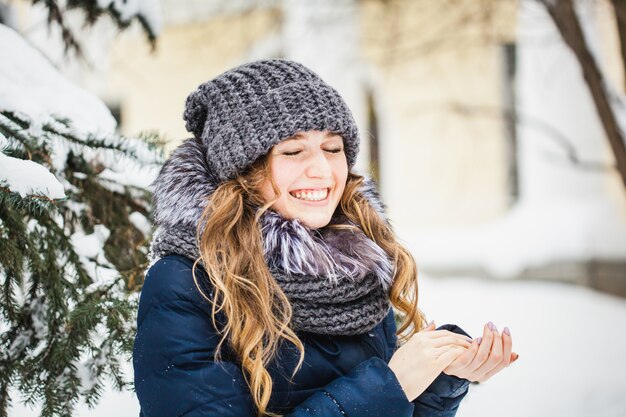 A girl of European appearance walks in the Park, forest, winter and snow, dressed in warm clothes, hat, jacket, scarf, rest, Hiking