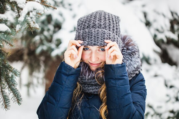 A girl of European appearance walks in the Park, forest, winter and snow, dressed in warm clothes, hat, jacket, scarf, rest, Hiking