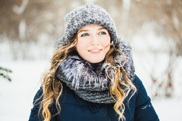 A girl of European appearance walks in the Park, forest, winter and snow, dressed in warm clothes, hat, jacket, scarf, rest, Hiking