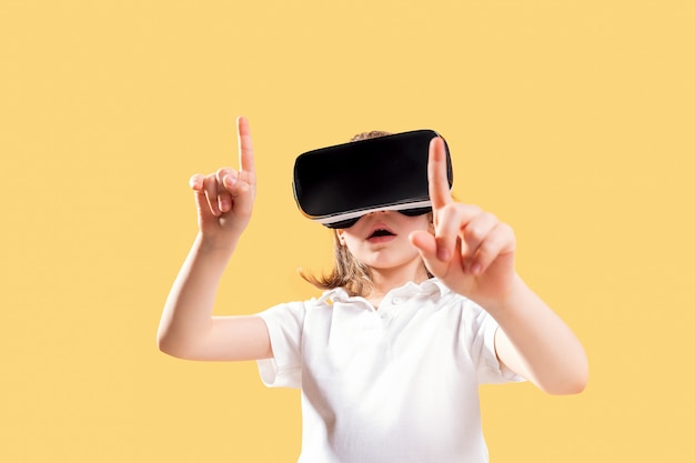 Girl experiencing VR headset game. Surprised emotions on her face.Child using a gaming gadget for virtual reality.