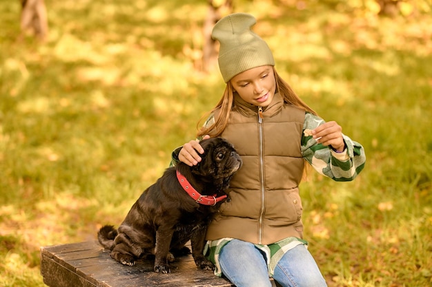 A girl feeding her dog and looking happy