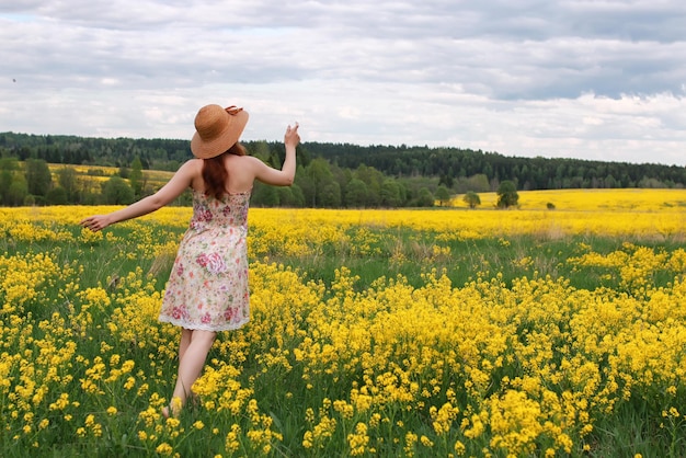 Girl in a field of flowers with basket and a hat