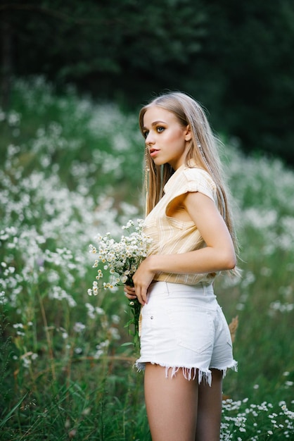 A girl in a field with flowers Beautiful young woman in a field with white meadow flowers