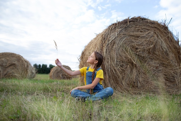 a girl in a field with straw