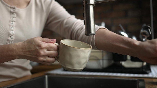 Girl filling cup with tap water