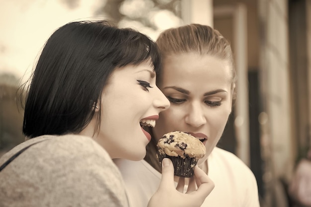 Girl friends eat blueberry muffin in paris france