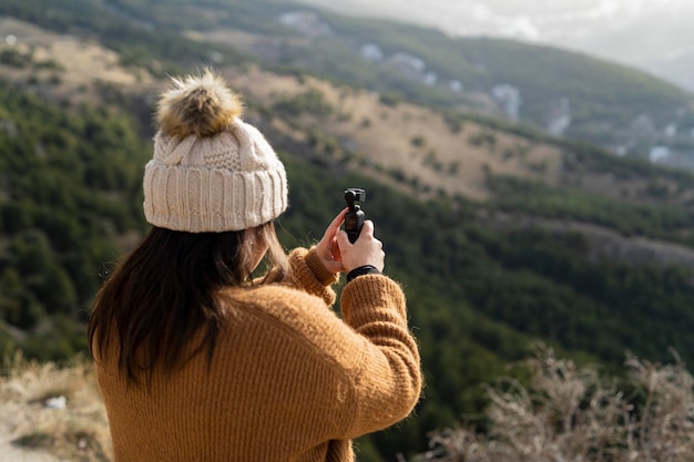 girl from behind taking video with device