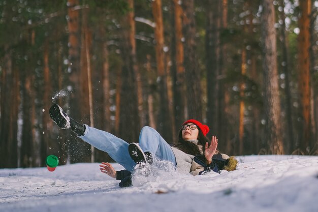 Girl funny fell on the wet snow in the forest