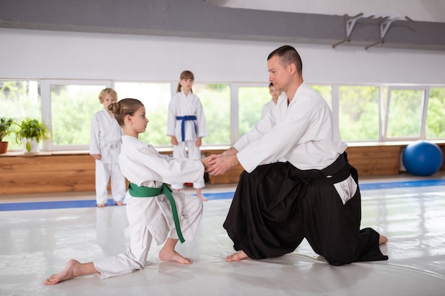 Girl getting ready for practicing aikido with her trainer