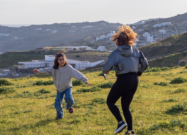 A girl and a girl run and take pictures at Orthodox Church on the island of Mykonos in Greece