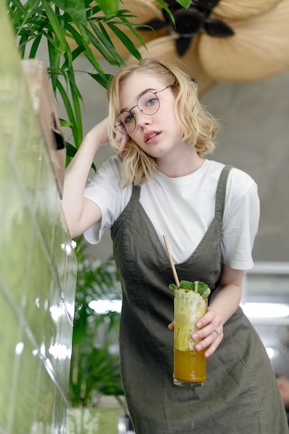 Girl in glasses holding a drink in his hands