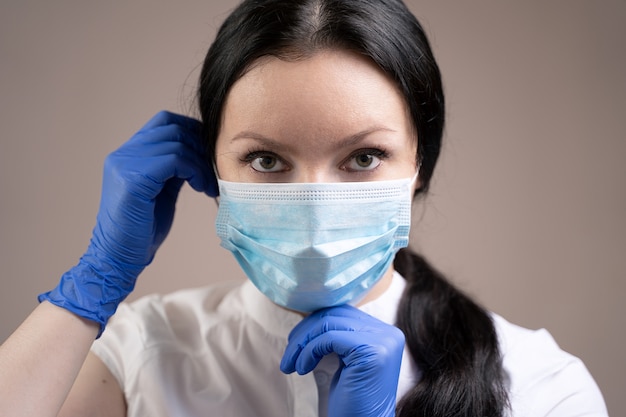 Girl in gloves putting on a mask