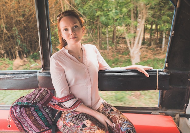 A girl goes on an elephant farm tour in the back of a taxi truck on Koh Chang Island Thailand