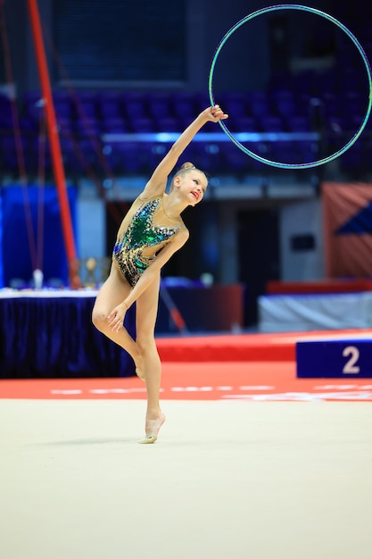 Girl gymnast performs an exercise with a hoop high quality photo