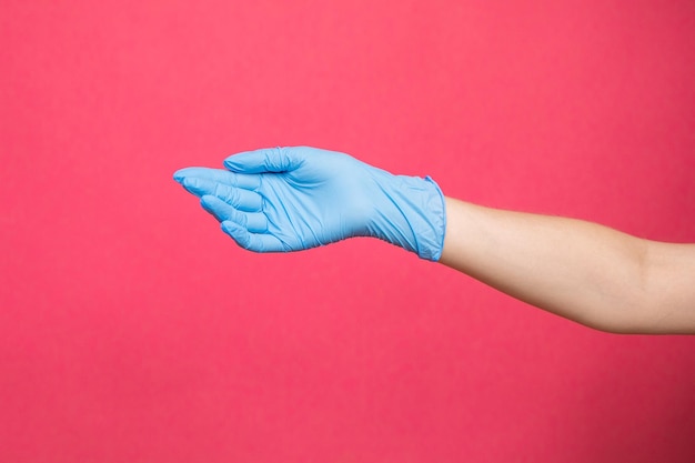 Girl hand in sterile gloves in pink background