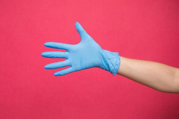 Girl hand in sterile gloves in pink background