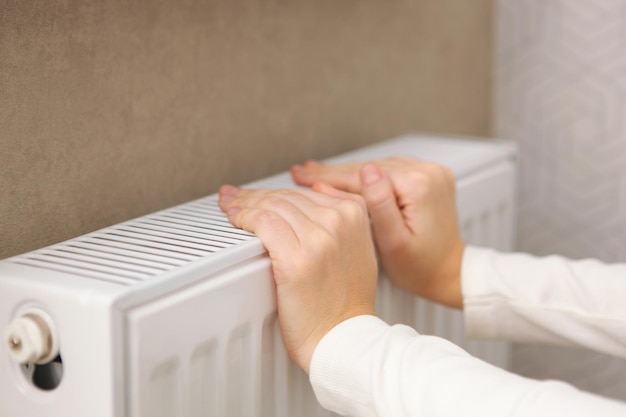 Girl hands checks the radiator for heat