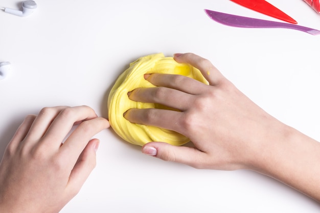 Girl hands playing with yellow slime