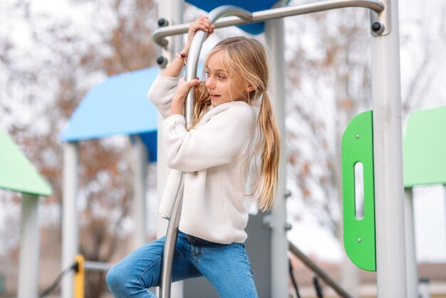 Photo girl hanging on metal in playground