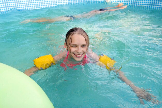 A girl happily swim in the pool in the summer