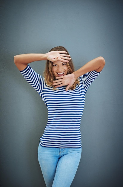 Girl happy and portrait in studio backdrop for fashion with joy for confidence trendy or style Female person outfit and fun in isolated excited and hand gesture for aesthetic in gray background