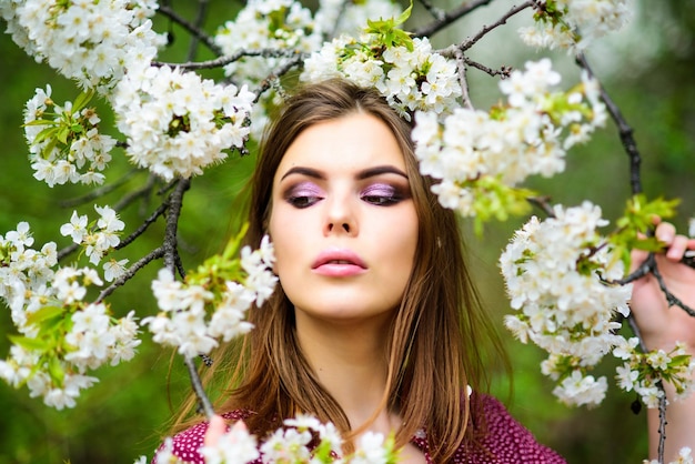 Girl in harmony with nature. Natural environment organic cosmetics. Spring freshness. Natural cosmetics concept. Makeup skin care. Blooming trees flowers. Natural beauty. Pretty woman skincare.