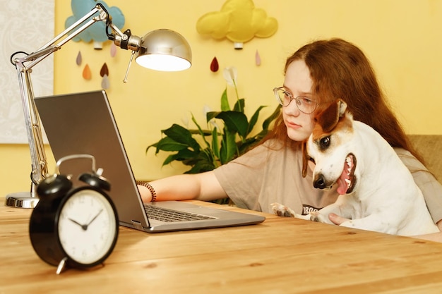 Girl and her friend dog working on computer