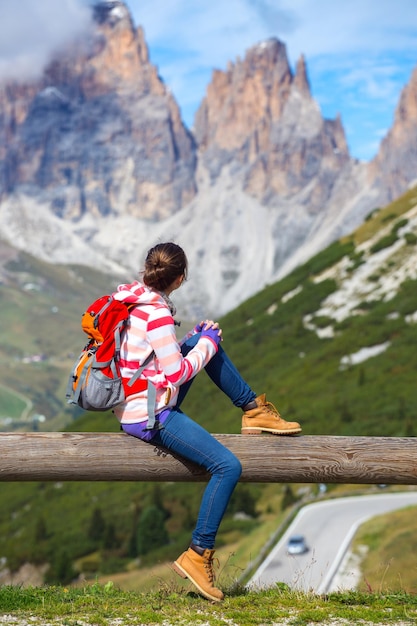 Girl hiker standing on a rock and looking at the mountains