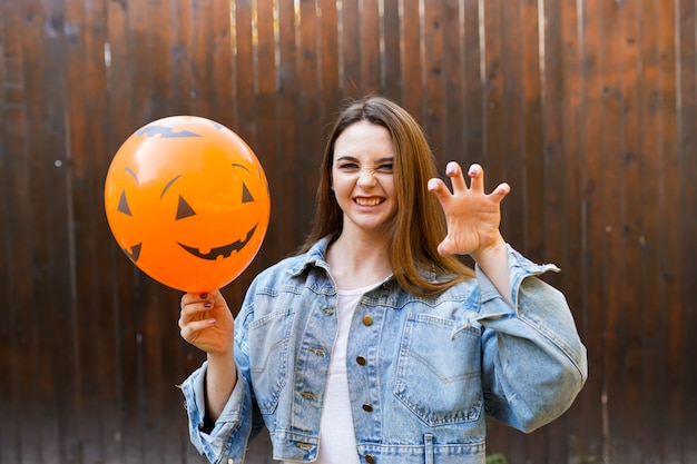 Girl holding ballon with pumpkin face