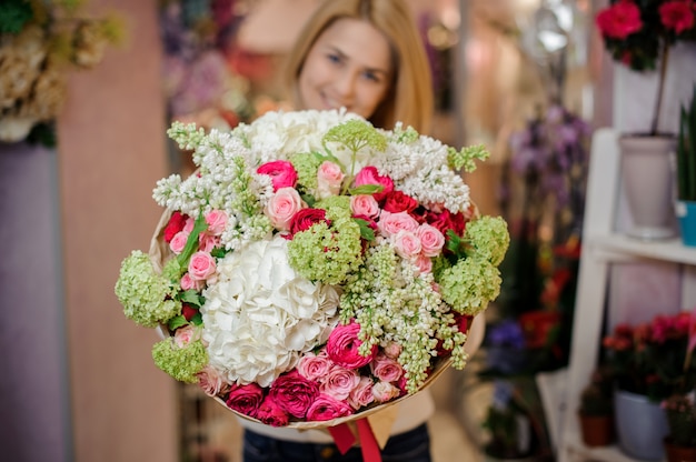 Girl holding a beautiful bouquet of magnolias and roses