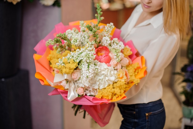 Girl holding a beautiful bright bouquet of white lilacs and roses