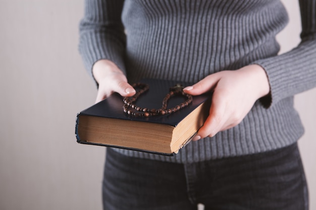 Girl holding a book and a cross