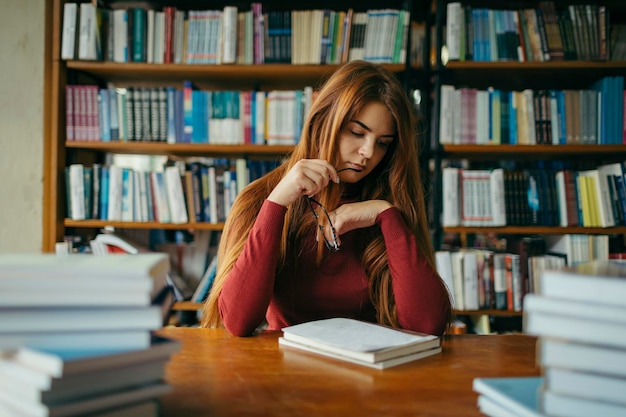 A girl holding a book shelf High quality photo Student in the library