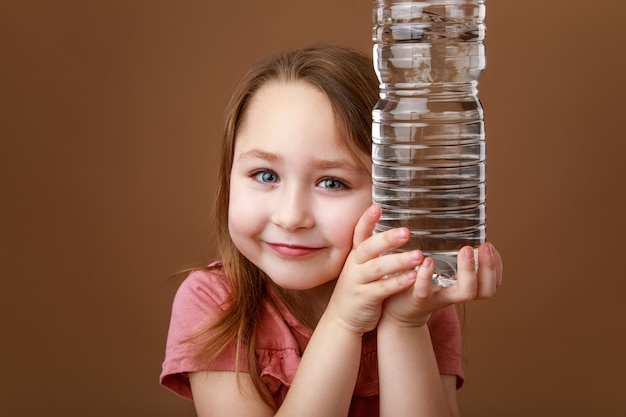 Girl holding bottle of water in hands