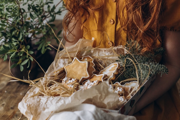 Girl holding a box of gingerbread cookies